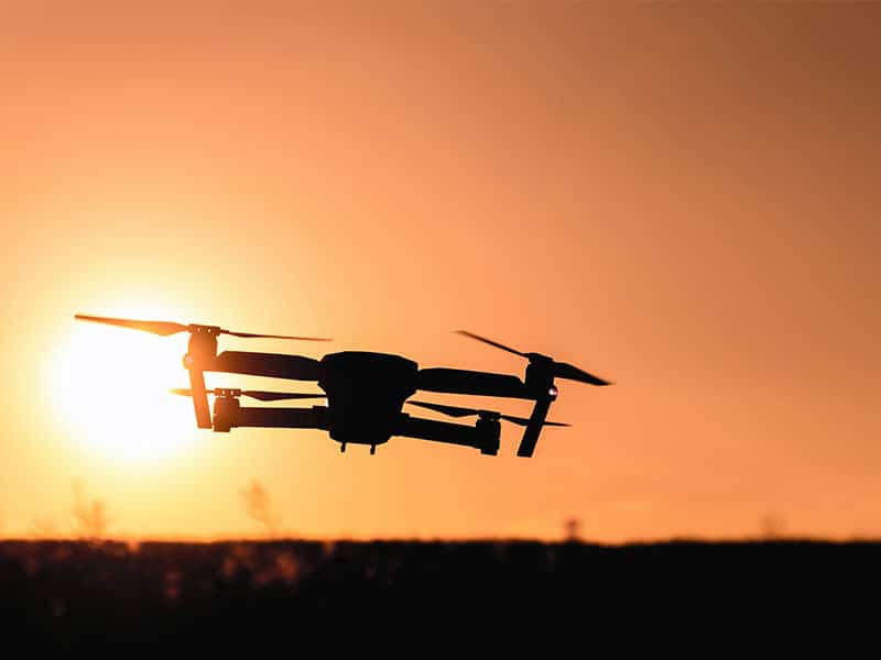 Drohne fliegt in den Sonnenuntergang